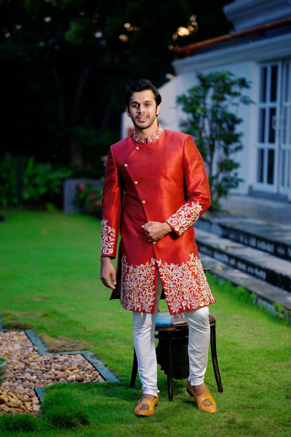 Ruby Red Side Open Indo Western Slim Achkan Suit with Golden Floral Handwork Detailing  paired with White Narrow Pants (Set of 3)