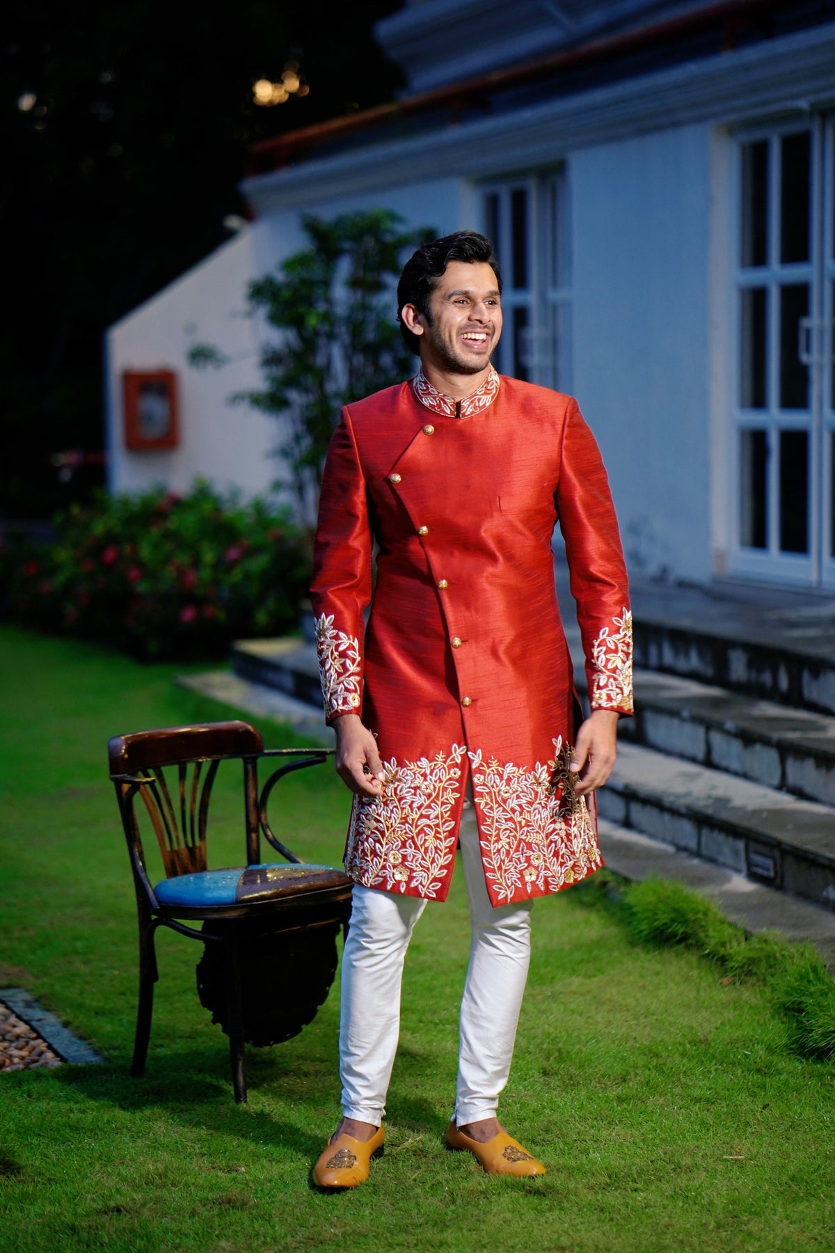 Ruby Red Side Open Indo Western Slim Achkan Suit with Golden Floral Handwork Detailing  paired with White Narrow Pants (Set of 3)