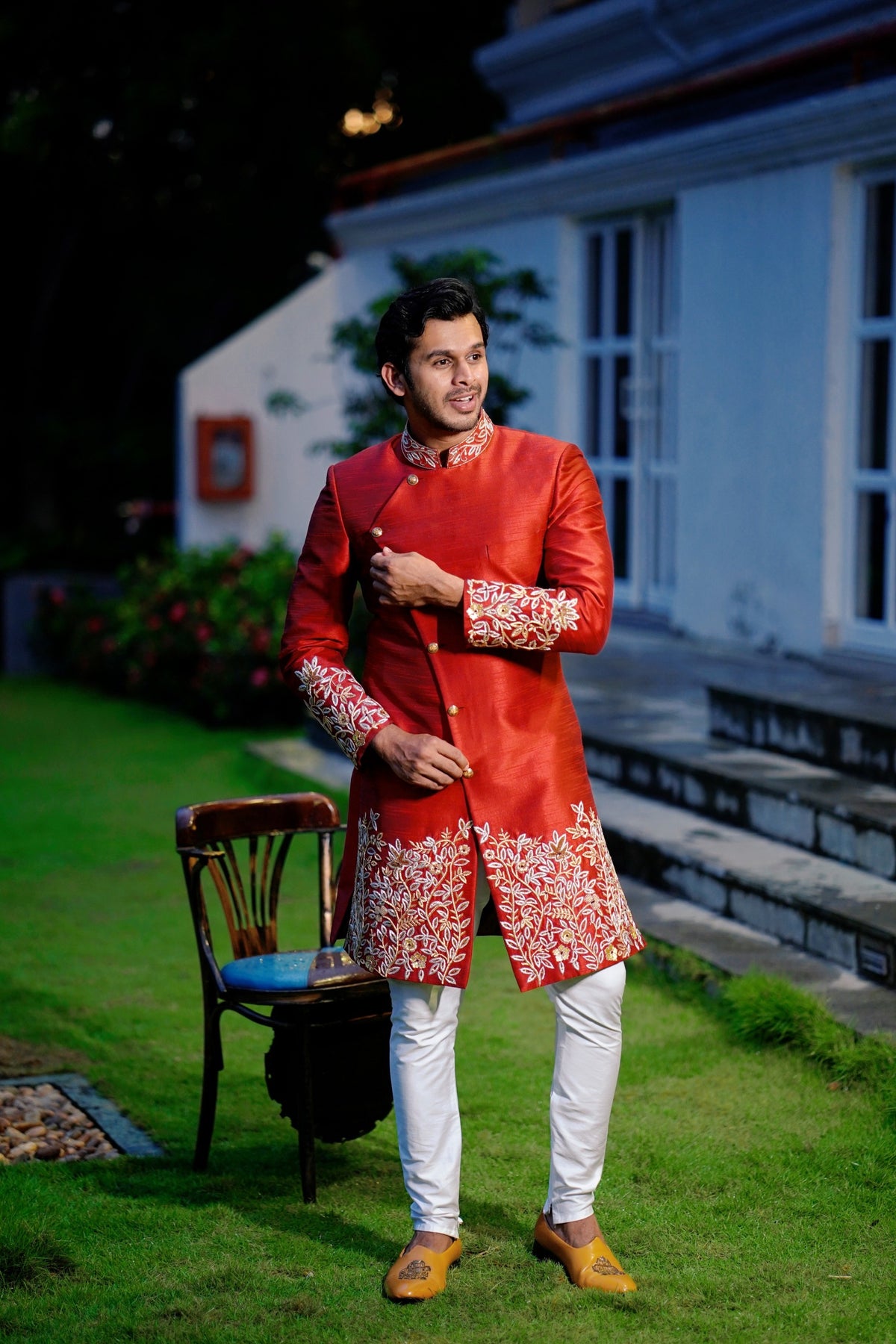 Ruby Red Side Open Indo Western Slim Achkan Suit with Golden Floral Handwork Detailing  paired with White Narrow Pants (Set of 3)